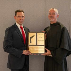 DEA Special Agent Tarentino accepting 2024 Assisi Award for Saint Francis University Alumnus Frank Tummillo killed in line of duty. Shown with SFU President Fr. Malachi Van Tassell, T.O.R.